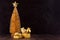 Christmas home decor in dark and golden color - Christmas tree, star, balls, gift box with shiny ribbons in elegant dark interior.