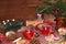 Christmas hot mulled wine with lemon and cinnamon on a festive wooden table. Christmas blanks with gifts, sweets and toys, fir