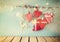 Christmas image of fabric red hearts and tree. wooden reindeer and garland lights, hanging on rope