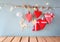 Christmas image of fabric red hearts and tree. wooden reindeer and garland lights, hanging on rope