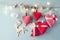 Christmas image of fabric red hearts and tree. wooden reindeer and garland lights, hanging on rope