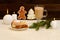 Christmas installation. Fir branch, gingerbread, pots, cake and candles on wooden background