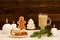 Christmas installation. Fir branch, gingerbread, pots, cake and candles on wooden background
