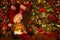 Christmas Kid opening Gift Box with Xmas Lights Garland. Cute Baby in Santa Hat sitting next to Decorated Fir Tree in Dark Room