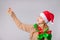 Christmas lady with a gentle gaze looks at a golden snowflake holding in her hand, pointing up finger