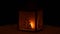 Christmas lantern with candle shining in the darkness, on the background of garlands