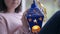 Christmas lantern in child hands with unrecognizable blurred Caucasian girl smiling sitting on windowsill. Happy curios