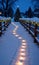 Christmas Lights Creating A Path In The Snow At Nigh. Generative AI