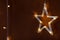 Christmas lights in the shape of a star . Yellow shiny illumination, Christmas decor, copy space. - Image