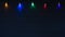 Christmas Lights on String Glowing against a Dark Navy Blue Wood Board Background with Copy Space below with a horizontal crop