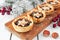 Christmas mincemeat tarts on a serving board. Table scene on white wood.