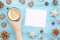 Christmas Mock up blank white paper sheet. Top view of woman`s hands holds coffee. Pine cone,wood star on blue