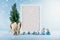 Christmas mock-up with white frame, Christma thuja tree and silver balls on blue background with falling snow