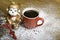 Christmas monkey near a red coffee cup.