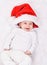 Christmas mood. Cute four month old caucasian baby in big-sized Santa hat laughing