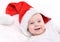 Christmas mood. Cute four month old caucasian baby in a Santa Claus hat laughing