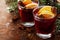 Christmas mulled wine or gluhwein with spices and orange slices on rustic table, traditional drink on winter holiday, magic light