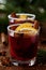 Christmas mulled wine or gluhwein with spices and orange slices on rustic table, traditional drink on winter holiday, magic light