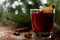 Christmas mulled wine or gluhwein with spices and orange slices on rustic table, traditional drink on winter holiday, magic light