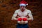 Christmas. Muscular Fighter kickbox boxing Santa Claus With Red Bandages the background of a brick wall.