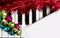 Christmas music concept. Blank paper on the piano with jingle bells and red tinsel