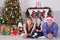 Christmas or New year celebration. Portrait of cheerful happy family of three people lying on the floor near Christmas tree with x