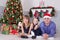 Christmas or New year celebration. Portrait of cheerful happy family of three people lying on the floor near Christmas tree with x