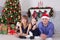 Christmas or New year celebration. Portrait of cheerful happy family of three people lying on the floor near Christmas tree with x