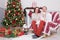 Christmas or New year celebration. Portrait of cheerful young family of three people near the Christmas tree with xmas gifts. A fi