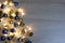 Christmas and New Year composition from blue and gold shiny and matte balls and christmas lights on light wood background