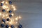 Christmas and New Year composition from blue shiny and matte balls and christmas lights on light wood background copy space