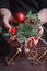 Christmas or New Year concept, in female hands a red burning candle and hellebore, selective focus