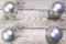 Christmas and New Year Concept. Four nacreous silvery New Year`s balls on corners of wooden board, Top view, flat lay