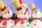 Christmas and new year decorations greeting post card. Funny snowmen toys in hats and scarfs with red noses