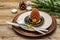 Christmas and New Year dinner place setting. Sweet snack, fir tree branch, candles, cones, ceramic plates, fork and knife. Winter