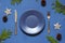 Christmas New Year empty plate flat lay on the blue background. Holiday table setting