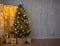 Christmas and new year evening background - christmas tree, heap of gifts, folding screen with lights and copy space over concrete
