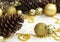 Christmas and New Year holiday background with decorations and beads. Gold shining balls, fir cones, jingle bells and star