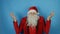Christmas and New year, man like a Santa Claus surprised and shocked, on blue background
