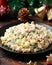 Christmas and New year Olivier salad, traditional Russian food with decoration, gifts, green tree branch on wooden