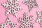 Christmas and New Year. Pink flat lay pattern with white wooden snowflakes.