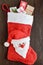 Christmas, New Year`s boot for gifts with a Santa face, full of gift boxes on a dark wooden background