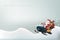 Christmas and New Year`s concept is presented with a Santa Claus riding a snow motor in the thick snow with reindeer and a huge
