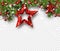 Christmas and New Year shiny background with fir branches, holly berries, snow and red stars