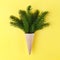 Christmas. New Year. Style minimalism. Christmas tree in ice cream cone on a yellow background.