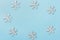 Christmas New Years background white snow flakes arranged in frame on blue backdrop. Minimalist elegant style for holiday poster