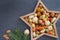 Christmas nuts and dried fruit mix in star-shaped bowl on dark background assortment of delicacies