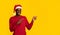 Christmas Offer. Cheerful Black Man In Santa Hat Pointing At Copy Space