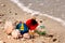 Christmas ornaments and shells on a sandy beach with a wave along the Gulf of Mexico for the holiday.