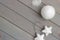 Christmas ornaments in white on a light gray wooden background. New Year`s accessories. View from above.